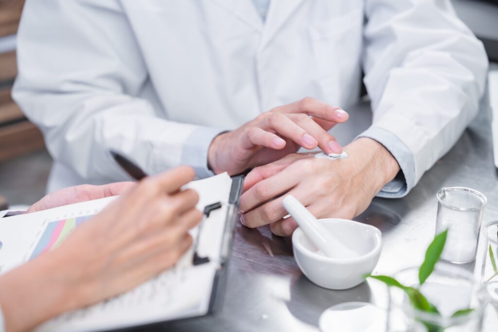 Beauty cosmetic research and development concept, Pharmacist and Scientist applying moisturizer lotion on her hand for efficacy testing of natural organic skincare products in biological laboratory